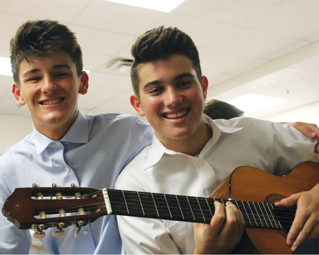 Two male students using guitars